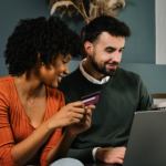 Dos personas frente a una computadora portátil mientras hablan sobre experiencia del cliente, equilibrio entre riesgo y conversión