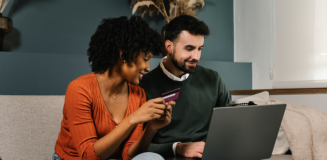 Dos personas frente a una computadora portátil mientras hablan sobre experiencia del cliente, equilibrio entre riesgo y conversión